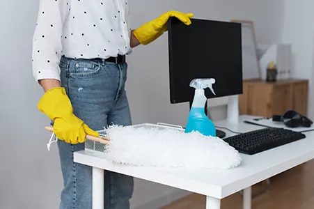 Cleaner disinfecting an office door handle