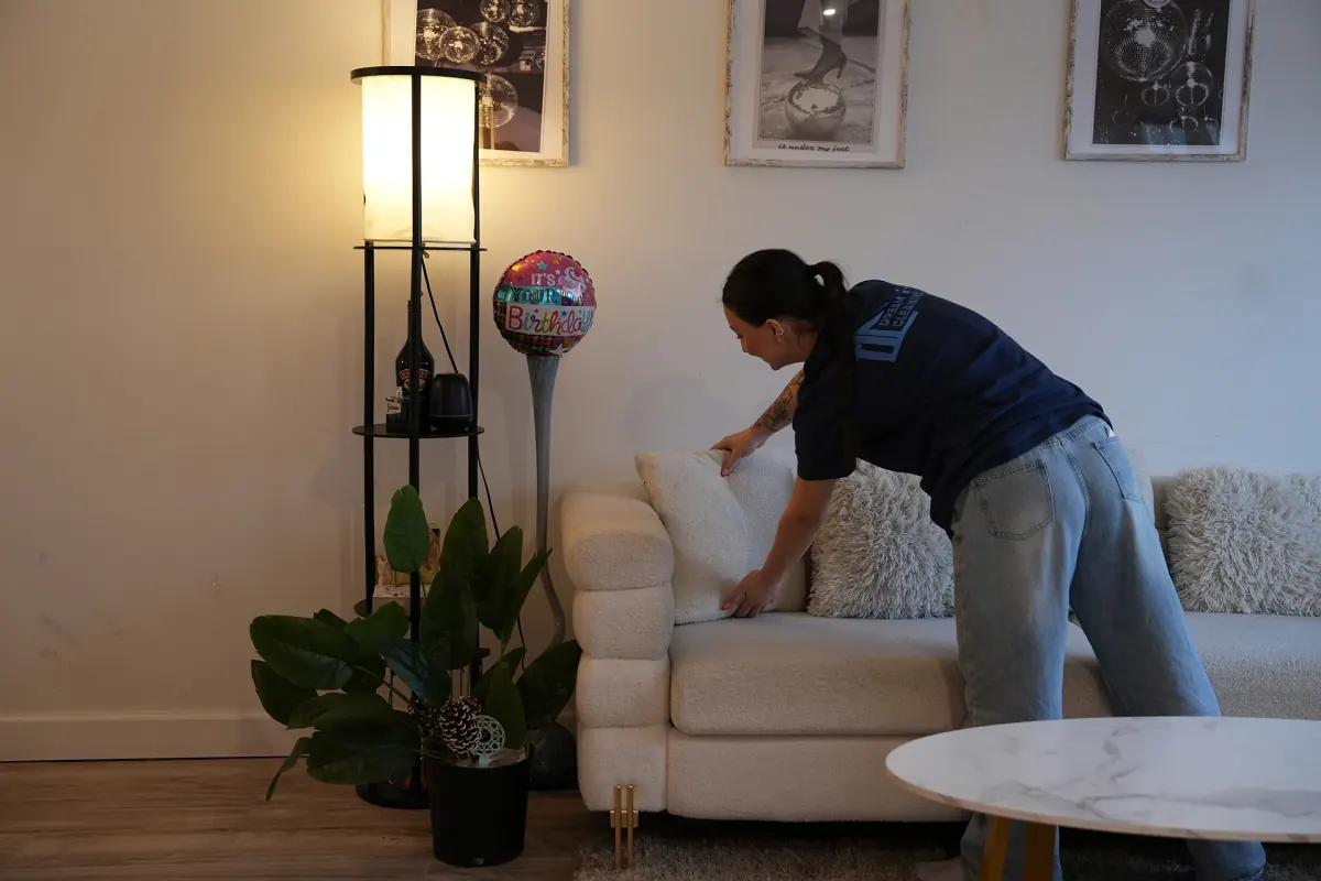 Sweep It Real cleaner wiping down a couch in a Cincinnati living room
